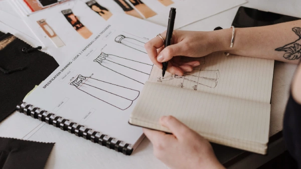 Fashion and Beauty Business Name Ideas - picture of a woman's hand sketching clothes